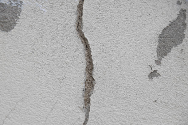 istock Concrete plaster wall with scratches, cracks and dents. 1290117020
