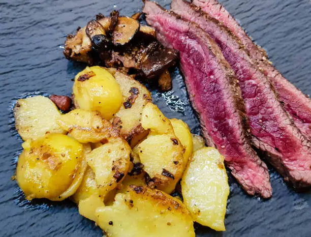 Flank steak with fried potatoes and forest mushrooms
