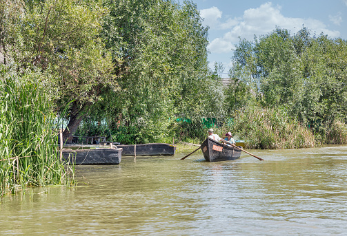 VILKOVE, UKRAINE - AUGUST 05, 2020: A local residents travels with in a paddle boat on the Danube river.