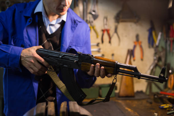 istock Gunsmith checks Kalashnikov assault rifle in weapons workshop 1290122267