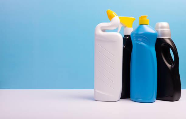 istock Cleaning concept with various plastic bottles and canisters on blue background. Various detergents and the necessary attributes for cleaning 1290122942