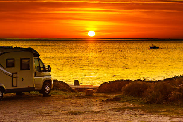 istock Camper vehicle on beach at sunrise 1290123039