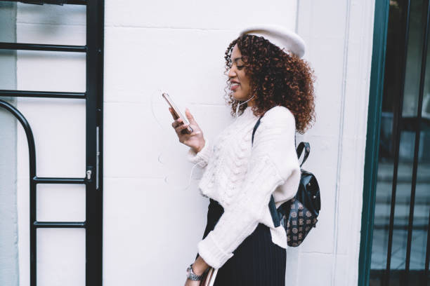 istock Cheerful ethnic woman using phone on street 1290124033