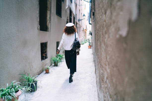 istock Young woman strolling on old street 1290124102