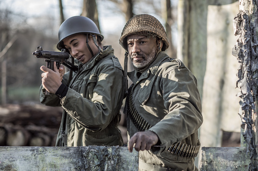 A black military male soldier and mixed race female agent during an outdoor operation in the autumn