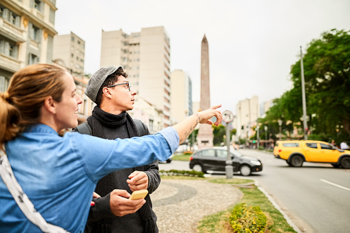 Woman helping a male tourist with directions in the city