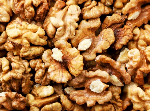istock Walnut kernels close-up, background. View of the top. 1290128447