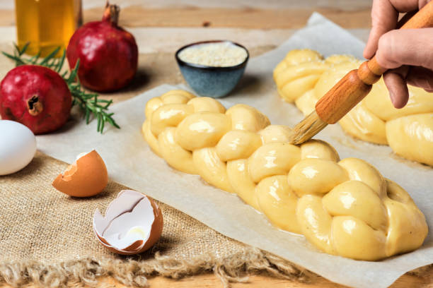 Easter baked goods, challah or zopf buns. Proof before placing in the oven. Brush on butter buns before baking. Close-up. Braided sweet bread dough. stock photo