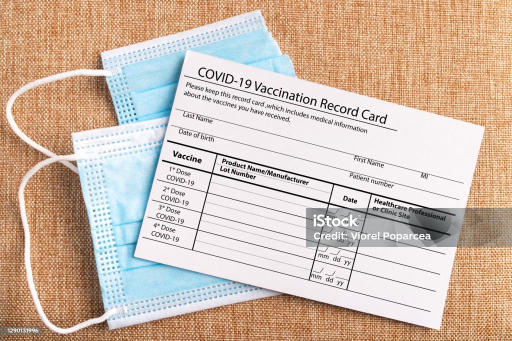 Coronavirus vaccination record card. Protective mask divided into two parts. Concept of defeating Covid-19 Coronavirus vaccination record card. Protective mask divided into two parts.Concept of defeating Covid-19. High quality photo Immunization Certificate Stock Photo