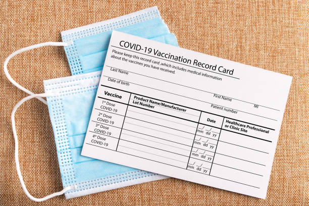 冠狀病毒疫苗接種記錄卡。防護面罩分為兩部分。擊敗科維德-19的概念 - covid 19疫苗 個照片及圖片檔