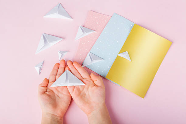istock Concept of DIY and kid's creativity, origami. Step by step instruction: how to make greeting cards with christmas trees origami. Step4 Bending triangles from rectangles. New year craft 1290132521