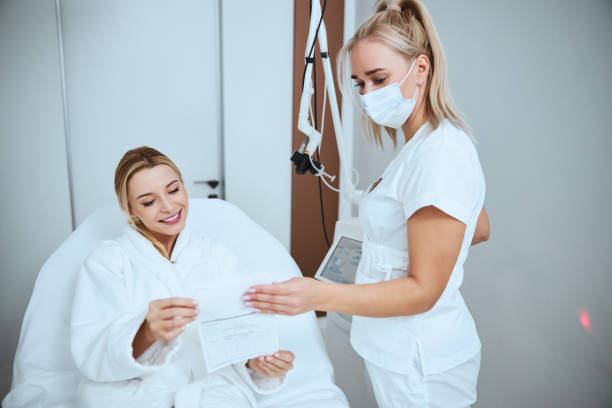 istock Smiling patient reading the document about the proposed cosmetic procedure 1290133622