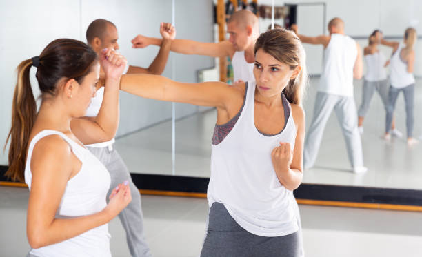 istock Young woman practicing self defence techniques with female partner 1290133759