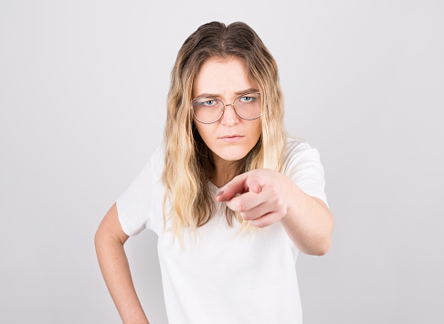 Young beautiful caucasian woman pointing displeased and frustrated to the camera, over isolated white background