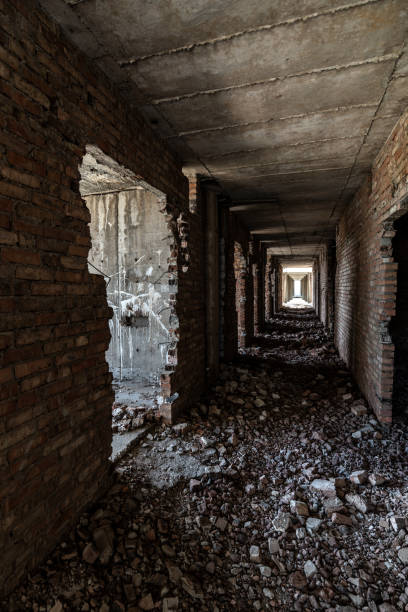 istock A long dark corridor in a dilapidated modern concrete building with broken brick walls 1290135341