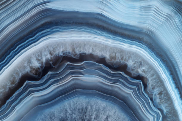 istock Full-screen close-up texture of translucent white-blue agate with a concentric pattern and ghostly quartz crystals 1290136100