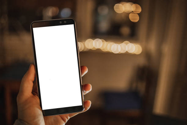 istock Personal perspective on a mobile phone at home with a white empty screen. POV 1290136617
