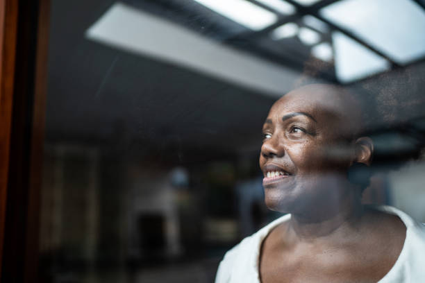 istock Senior woman looking through the window 1290137766