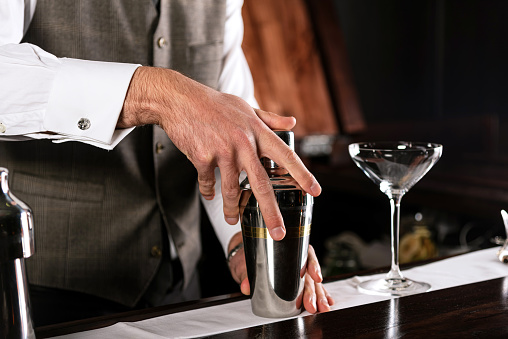 Bartender mixing cocktail at bar on bar counter