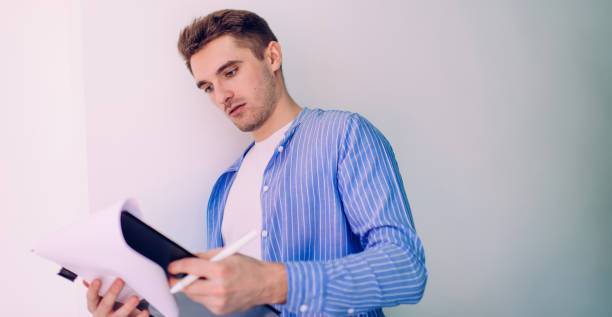istock Side view of intelligent male student analyzing course work report during learning time near publicity area with copy space area for education information, smart casual man reading knowledge test 1290146862