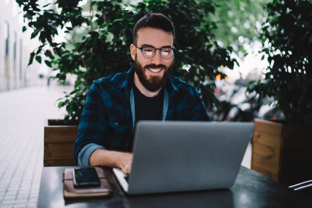 istock Happy freelancer working at laptop in outdoor cafe 1290147392