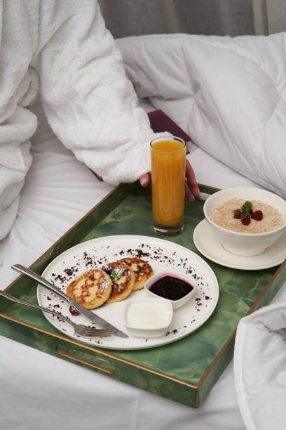 istock Woman reading book while having breakfast in bed. 1290151881