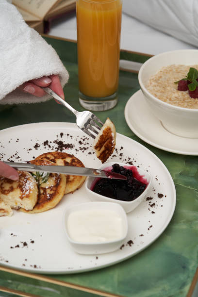 istock Woman reading book while having breakfast in bed. 1290151889