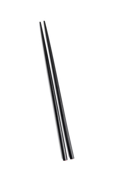 istock Two Black wooden chopsticks isolated on white background 1290154068