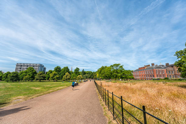 kensington palace vicino a giardini a hyde park con persone che camminano sul sentiero in estate con cielo blu - duke gardens foto e immagini stock