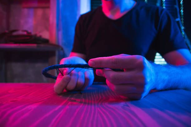 istock Craftsman creating dreamcatcher in dark futuristic workshop. 1290157561