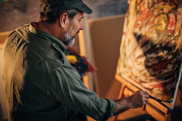 istock Senior painter painting in his home studio 1290160096