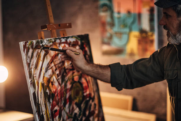 istock Painter painting late into the night in his home studio 1290161821