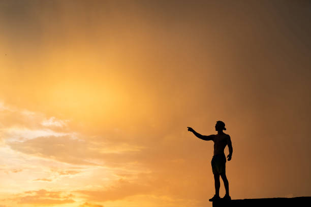 istock Silhouette of Man stepping from the edge during dramatic sunset. Concept goal, step forward and risk 1290164692