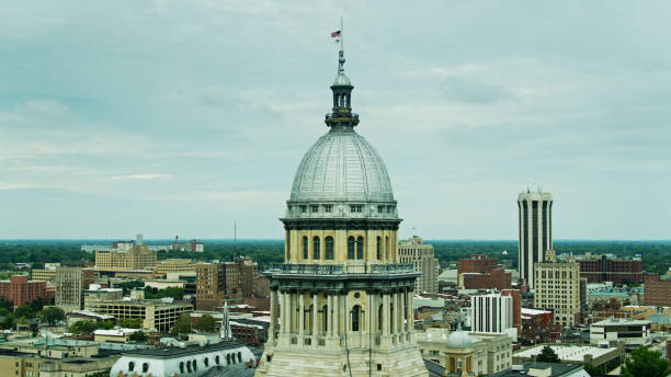 istock US and Illinois State Flag Flying Over State Capitol Building - Drone 1290167191