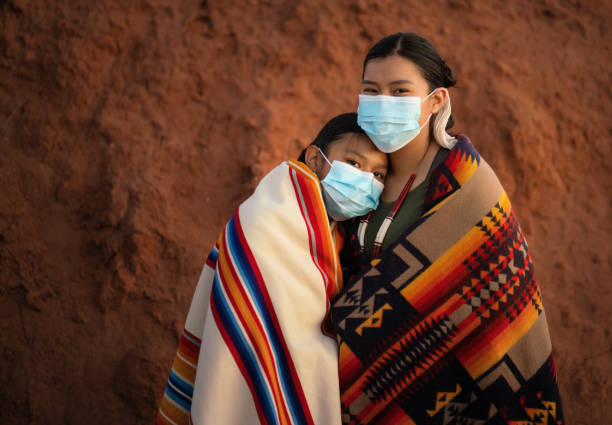 Navajo sisters with face mask in front comforting each other during covid-19 quarantine Navajo sisters with face mask in front comforting each other during covid-19 quarantine navajo nation covid stock pictures, royalty-free photos & images