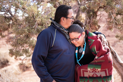 Navajo father hugging and comforting her daughter in Tribal Park - Arizona