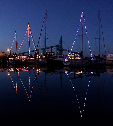 The lights of three decorated sailboats at Christmas time