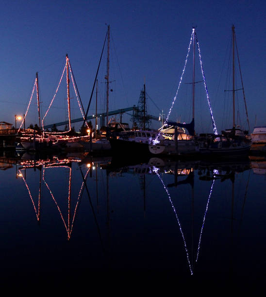 The Lights Of Three Decorated Sailboats The lights of three decorated sailboats at Christmas time mast sailing photos stock pictures, royalty-free photos & images