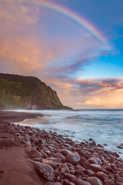 Waipio Valley coastline at sunrise with a rainbow Waipio Valley beach and cliffs at sunrise with a rainbow in the distance oahu photos stock pictures, royalty-free photos & images