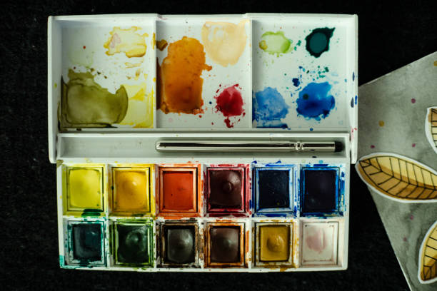 istock a palette and watercolors with brushes, horizontal 1290182131