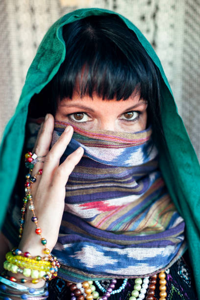 istock Black-haired woman covers with hijab her face. 1290188213