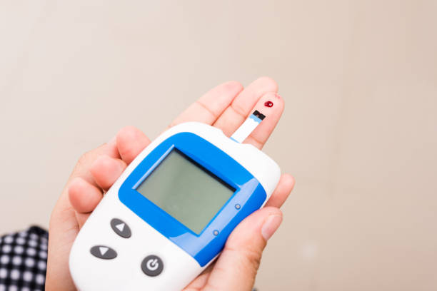 istock woman measuring glucose test level check with blood on finger by glucometer 1290189220