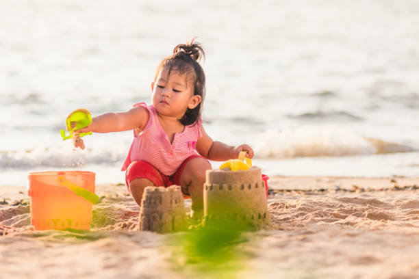 istock little girl playing sand with toy sand tools 1290189603