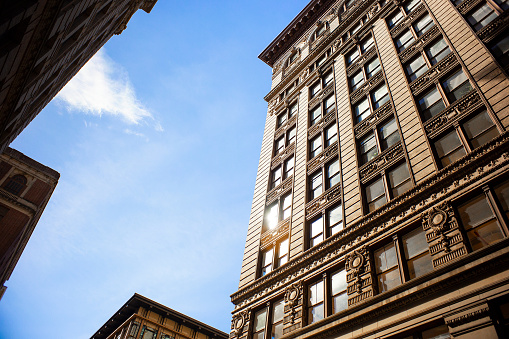 A pedestrian's perspective of buildings and sky in downtown New York City.