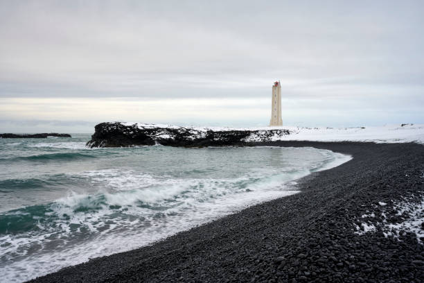 istock Snowy seashore with lighthouse on stormy day 1290190116