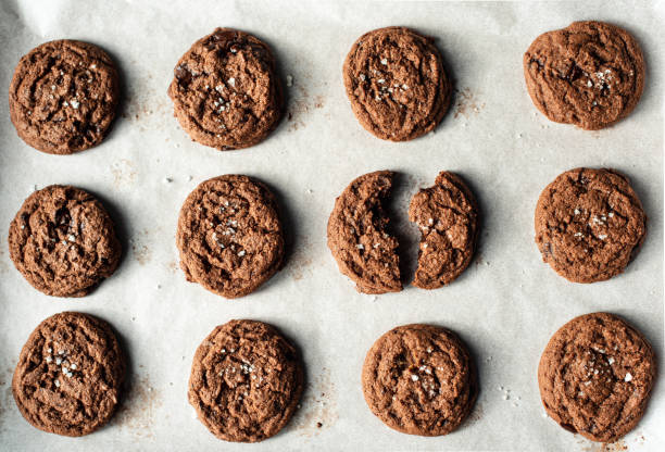 istock Salted dark chocolate cookies on pan lined with parchment paper. 1290190700