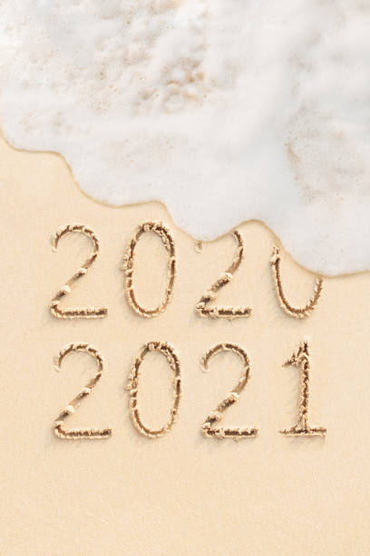 istock 2021 and 2020 handwritten on the sand 1290207781