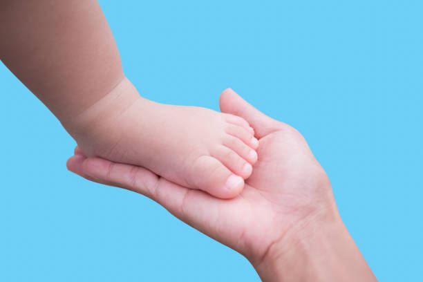 istock Baby feet on mom palm 1290212831