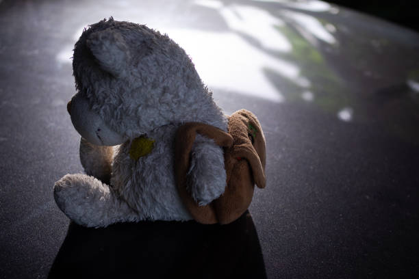 istock Broken heart concept. Alone teddy bear sitting on black dark floor. conveys a lonely mood, chagrin, lovelorn. 1290213485