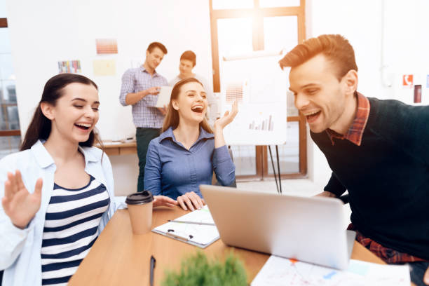 istock Happy creative people laugh near laptop in office. Having fun at work. 1290213716